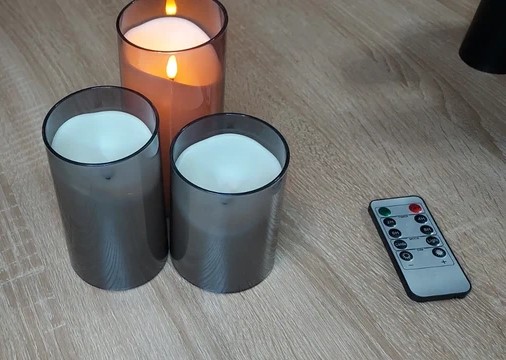 Drie grijze plastic kaarsen branden als echte kaarsen