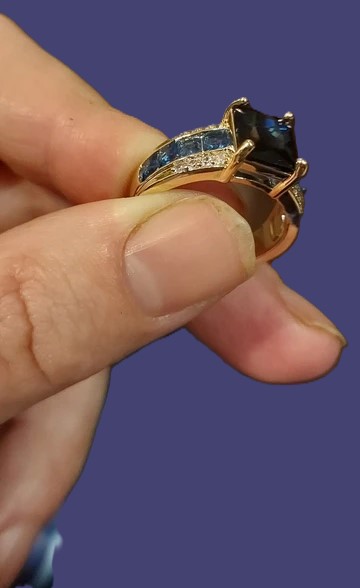 metalen goudkleurige ring met ingelegde blauwe steen